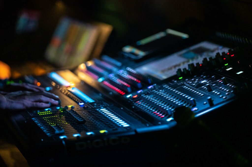 The silent dawn that birthed Tony Overstar's Unchained — analog mixing console in dark music studio glowing lights