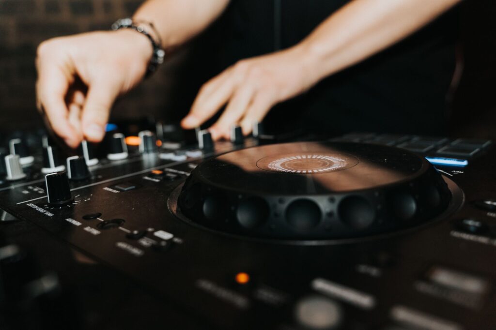 The four-minute rebellion of Eric Prydz's Opus — dj hands close up on mixer in dark club