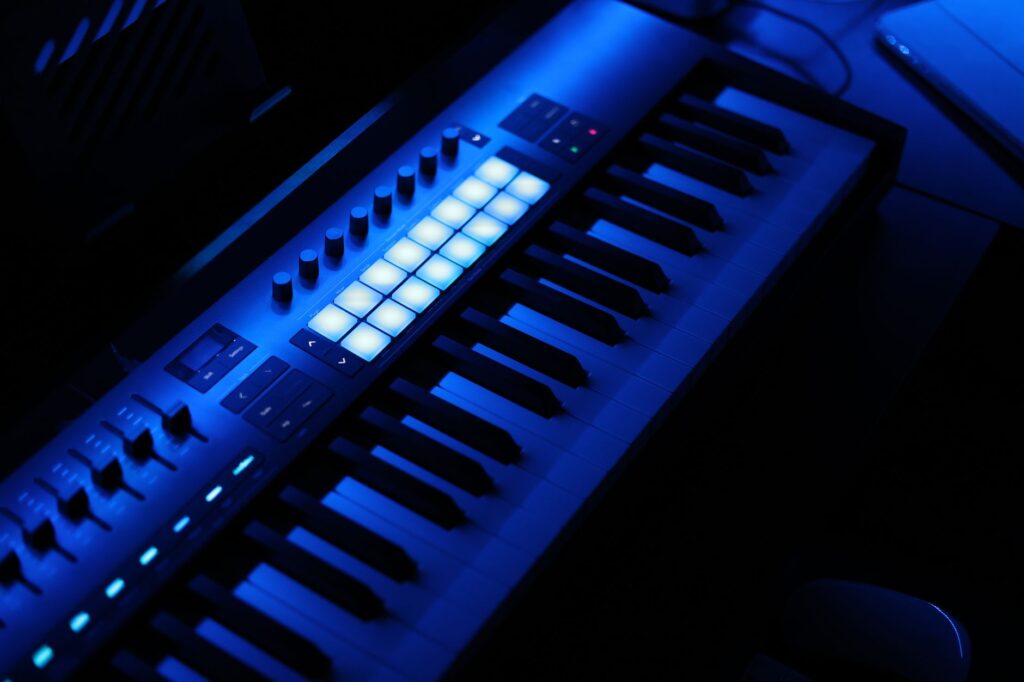 Why Tiësto's Adagio for strings still saves the dancefloor — analog synthesizer in dark music studio neon lights blue red