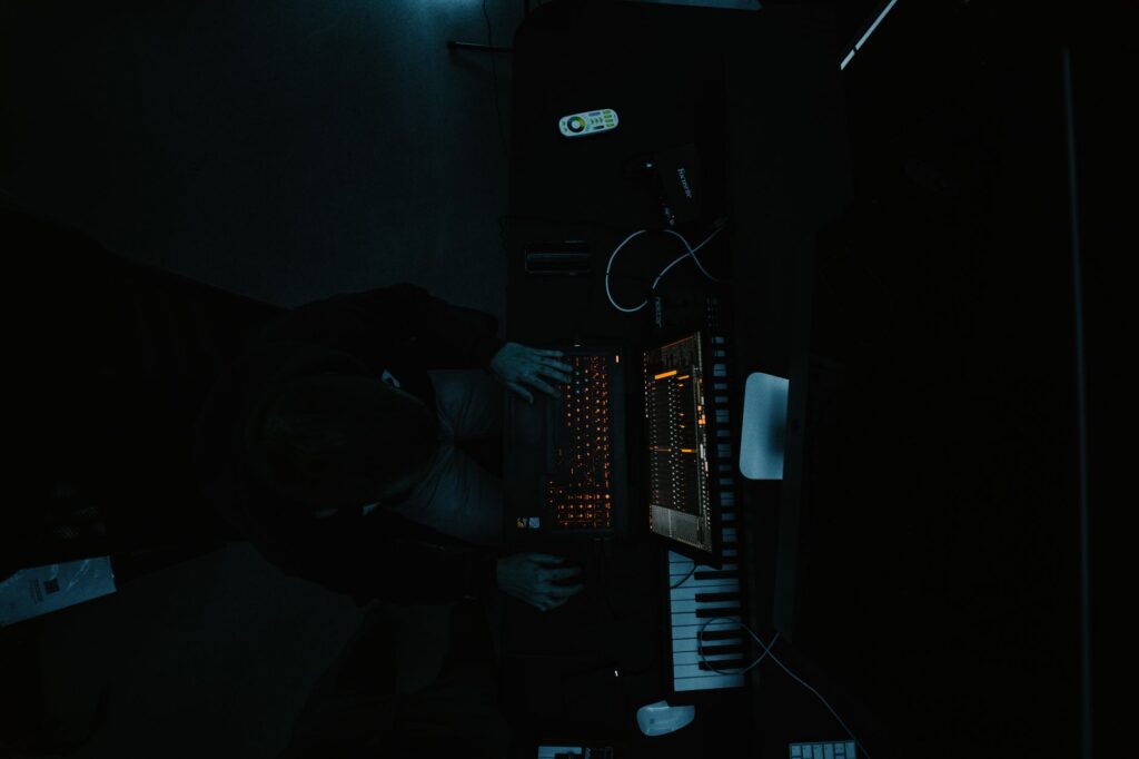 The painful truth behind Zedd and Foxes' masterpiece Clarity — man looking at laptop in dark music studio glowing screen