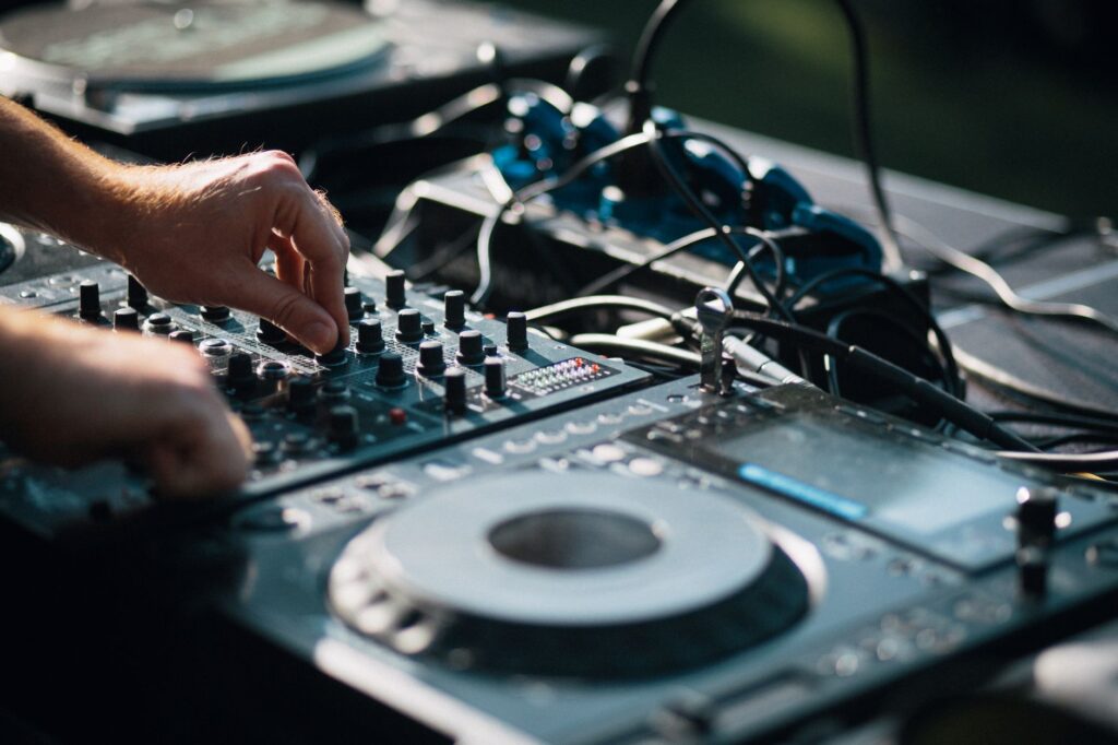 Refuge NYC marks its first anniversary with a stacked September lineup โ dj hands on mixer vinyl record spinning close up